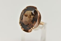 A 9CT GOLD SMOKY QUARTZ DRESS RING, designed as a large oval smoky quartz within a scalloped setting