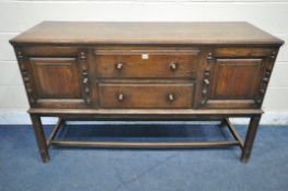 A 20TH CENTURY OAK SIDEBOARD, fitted with two cupboard doors, flanking two drawers, on block legs,