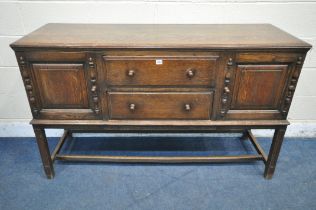 A 20TH CENTURY OAK SIDEBOARD, fitted with two cupboard doors, flanking two drawers, on block legs,