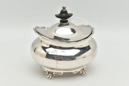 A GEORGE V SILVER TEA CADDY OF OVAL FORM, the hinged cover fitted with an ebony finial, on four