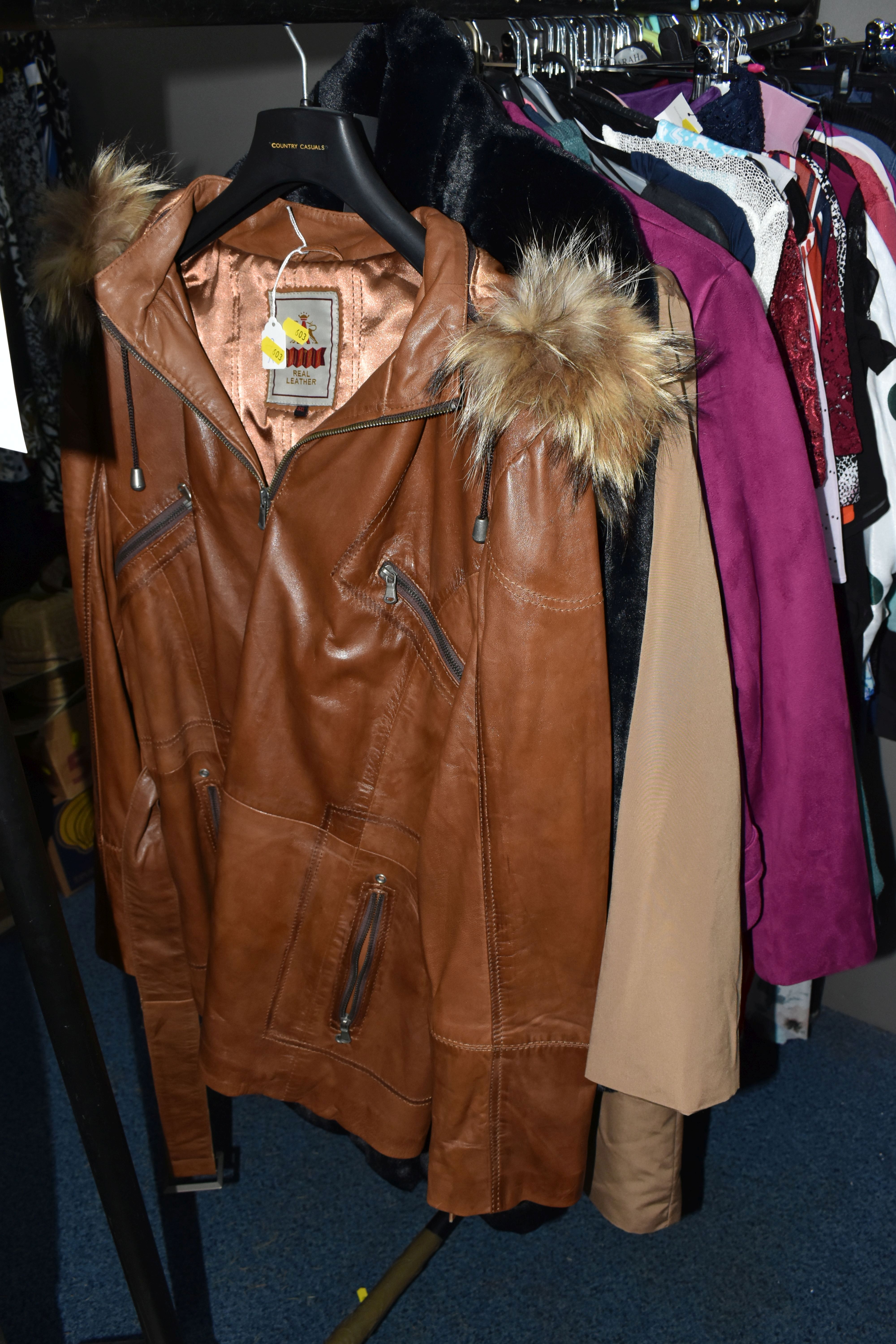 A QUANTITY OF MODERN UNUSED LADIES' CLOTHING, to include a brown leather jacket, black faux fur, - Image 4 of 27