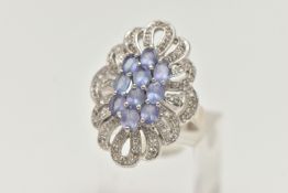 A 14CT WHITE GOLD TANZANITE AND DIAMOND DRESS RING, designed as a central cluster of oval cut