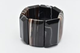 A BANDED AGATE BRACELET, eight panels of carved banded agate, on a stretch bracelet, approximate