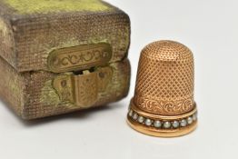 A LATE VICTORIAN YELLOW METAL THIMBLE, textured detail and a split pearl rim, unmarked,