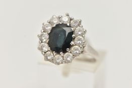 A 9CT WHITE GOLD SAPPHIRE AND PASTE CLUSTER RING, designed as a central oval sapphire within a