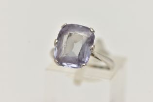 A GEM SET RING, an elongated cushion cut bule stone, assessed as synthetic sapphire, prong set in