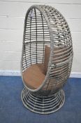 A FAUX RATTAN SWIVEL EGG CHAIR, with brown upholstered cushions, width 87cm x depth 82cm x