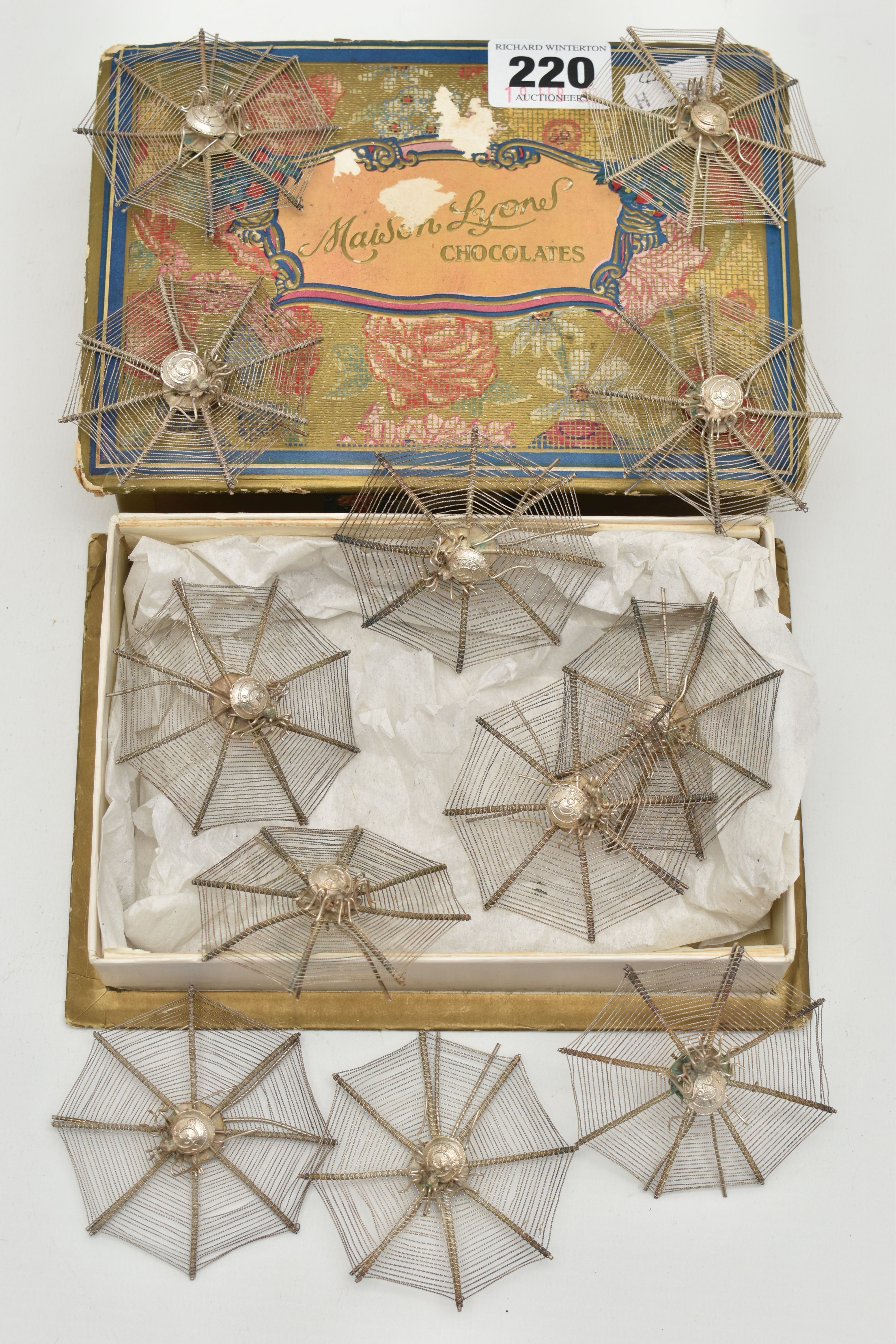 A SET OF TWELVE NOVELTY WHITE METAL OCTAGONAL FILIGREE EASEL BACK PLACE NAME HOLDERS IN THE FORM