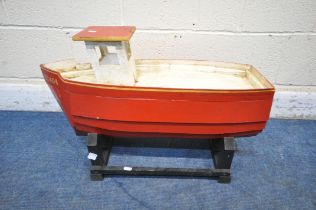 A SMALL BESPOKE MODEL OF A BOAT, red and white painted, with gold painted trim, on a separate stand,