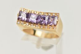 A YELLOW METAL DRESS RING, a rectangular form mount with concave detail, set with four purple square