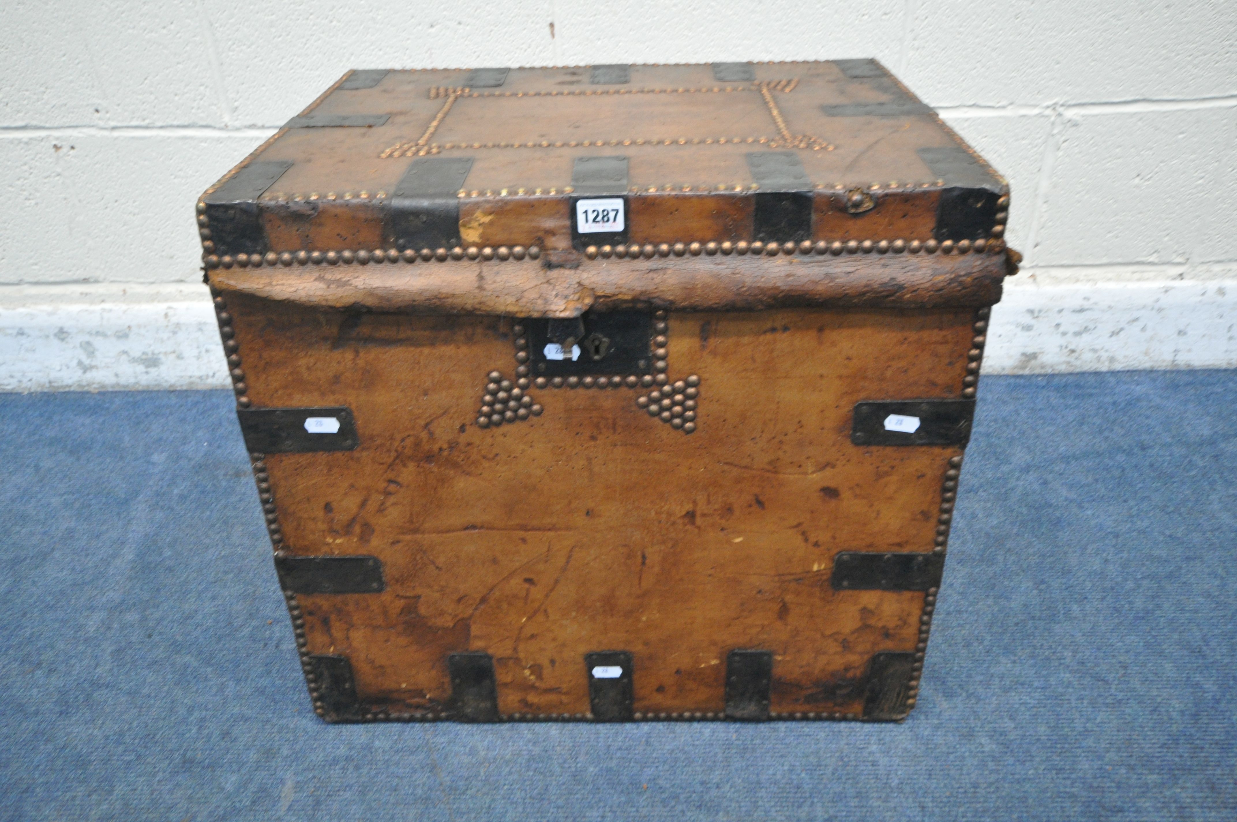 A VICTORIAN TANNED LEATHER TRUNK, with metal banding, twin leather handles and studded details,