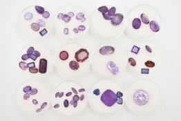 A SELECTION OF LOOSE FACETED MAINLY PURPLE GEMSTONES, to include a large circular purple cubic
