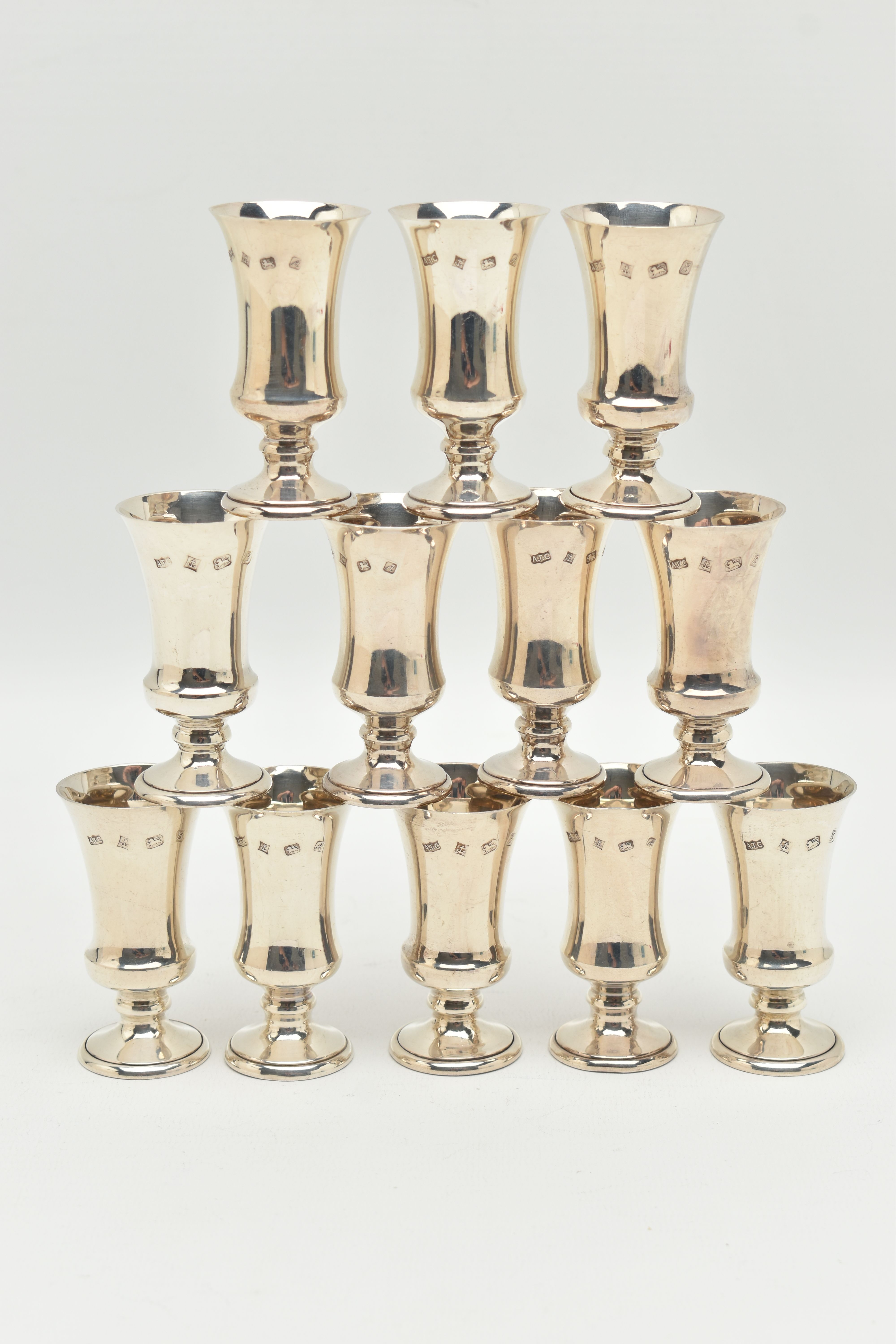 A SET OF TWELVE SILVER LIQUOR/SHERRY CUPS, tapering on round based, gilt interiors, hallmarked 'A