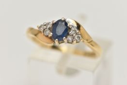 A SAPPHIRE AND DIAMOND RING, a principally set oval cut sapphire, flanked with six round brilliant