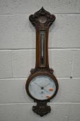 AN EARLY 20TH CENTURY OAK BAROMETER, with scrolled and shell decoration, the thermometer above an