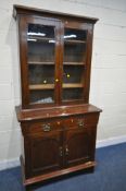 A 20TH CENTURY OAK BOOKCASE, the double glazed doors enclosing three shelves, above two drawers