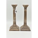 A PAIR OF ELIZABETH II SILVER CORINTHIAN COLUMN CANDLESTICKS, on stepped weighted square bases,