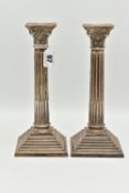 A PAIR OF ELIZABETH II SILVER CORINTHIAN COLUMN CANDLESTICKS, on stepped weighted square bases,