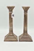 A PAIR OF ELIZABETH II SILVER CORINTHIAN COLUMN CANDLESTICKS, on stepped weighted square bases,