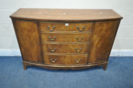 A 20TH CENTURY MAHOGANY BOW FRONT SIDEBOARD, with double doors, flanking four graduated drawers, the