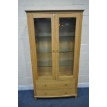 A SOLID LIGHT OAK BOW FRONT BOOKCASE, the double glazed doors enclosing three glass shelves, above