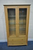 A SOLID LIGHT OAK BOW FRONT BOOKCASE, the double glazed doors enclosing three glass shelves, above