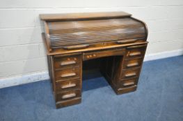 A 20TH CENTURY OAK ROLL TOP DESK, with a fitted interior, above an arrangement of five drawers and