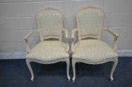A PAIR OF FRENCH CREAM ARMCHAIRS, with a foliate crest, scrolled open armrests, on front cabriole