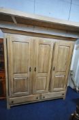A LARGE GOOD QUALITY LIGHT OAK TRIPLE DOOR WARDROBE, with a fixed cornice, an arrangement of