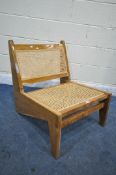 IN THE MANNER OF PIERRE JEANNERET FOR CHANDIGARH, A MID CENTURY HARDWOOD KANGAROO CHAIR, with cane
