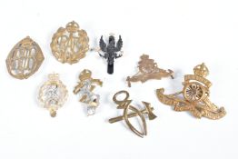 A SMALL AMOUNT OF CAP BADGES FROM DIFFERENT ERAS, to include RAF, a distressed RA badge, REME, a