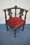 A LATE 19TH/20TH CENTURY OAK CORNER CHAIR, carved with foliate detail, a central mask, two splat