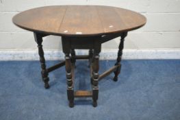 AN EARLY 20TH CENTURY OAK GATE LEG TABLE, raised on turned supports, united by stretchers, open
