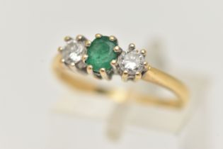 AN 18CT GOLD EMERALD AND DIAMOND RING, the central oval emerald flanked by brilliant cut diamonds,