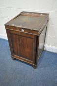 A DISTRESSED REGENCY ROSEWOOD DAVENPORT, the sliding top with a hinged lid enclosing a fitted