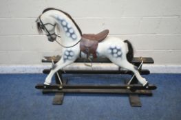 AN EARLY 20TH CENTURY PAINTED ROCKING HORSE, with real horse hair, leather saddle, on a black
