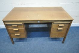 A 20TH CENTURY OAK DESK, with two slides and five drawers, width 140cm x depth 75cm x height 76cm (