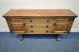 A 20TH CENTURY OAK OLD CHARM SIDEBOARD, fitted with two cupboard doors, flanking three drawers,