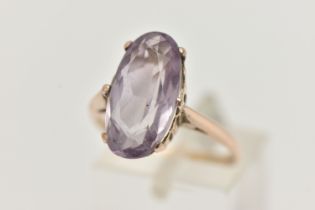AN AMETHYST RING, the large oval amethyst in a six claw setting, to the plain tapered band,