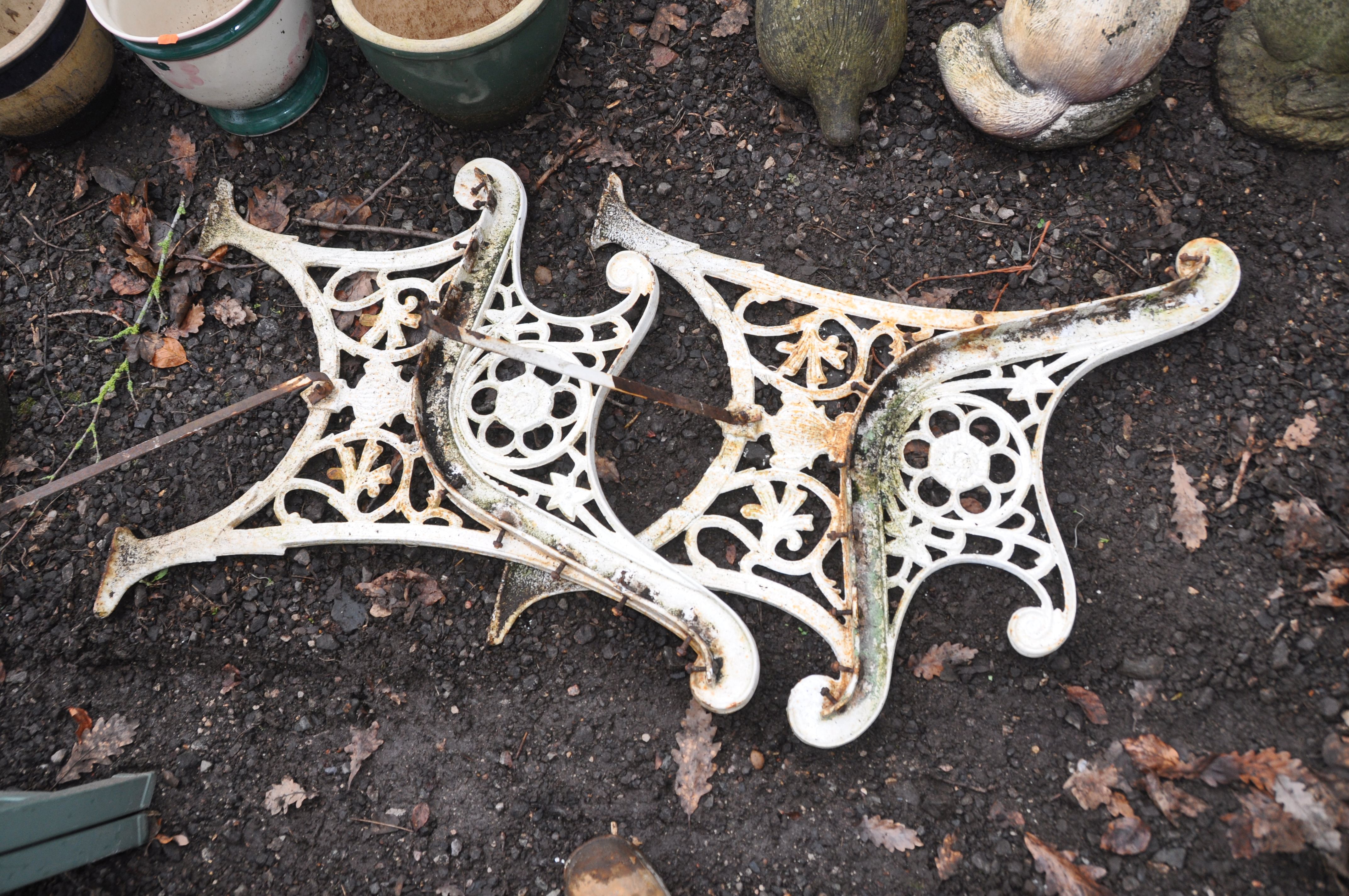 A PAIR OF CAST IRON BENCH ENDS overpainted in white