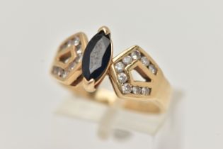 A YELLOW METAL SAPPHIRE AND DIAMOND DRESS RING, centering on a marquise cut deep blue sapphire, to