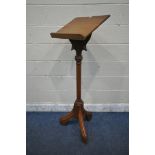 A 20TH CENTURY OAK LECTERN, with shaped supports, raised on a hexagonal pillar, with three legs,