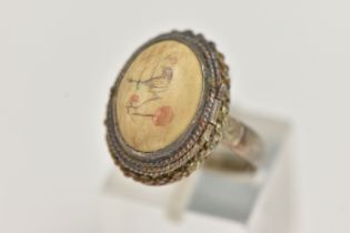 A WHITE METAL RING, of an oval form, set with a cabcohon with bird detail, on a hinged cover, fine