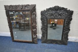 AN EBONISED RECTANGULAR FOLIATE CARVED WALL MIRROR, with a lion mask and bevelled mirror plate, 65cm