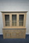 A MODERN OAK EFFECT WALL CABINET, the two glazed doors enclosing two glass shelves, above three
