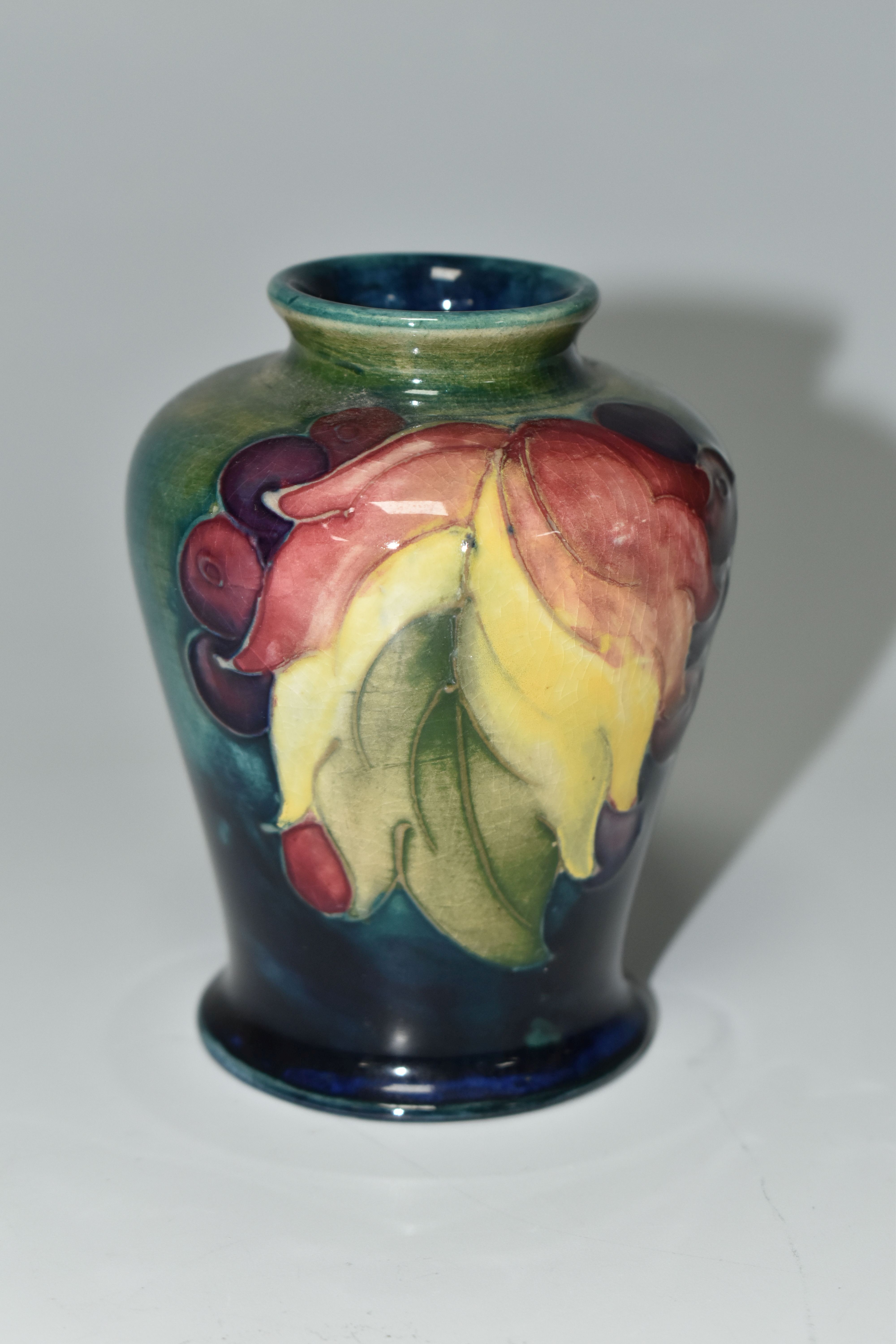 A MOORCROFT POTTERY 'LEAF AND BERRY' PATTERN VASE, of small shouldered form, tube lined with