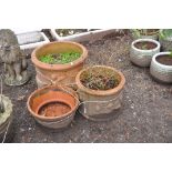 THREE TERRACOTTA PLANT POTS with embossed detailing to external edges the largest being 52cm in