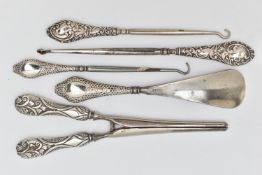 FIVE SILVER HANDLED ITEMS, to include three button hooks, a shoe horn and a pair of glove