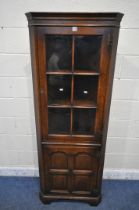 A TITCHMARSH AND GOODWIN OAK CORNER CUPBOARD, a single glazed door, above a cupboard door, width