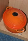 AN OVAL LE CREUSET COVERED CASSEROLE DISH, Orange colourway (1) (Condition Report: no obvious damage
